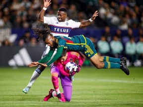 L.A. Galaxy forward Raheem Edwards, centre, collides with goalkeeper Jonathan Bond, bottom, in front of Vancouver Whitecaps forward Cristian Dajome during the first half of an MLS match in Carson, Calif., Saturday. Photo: Ringo H.W. Chiu/AP
