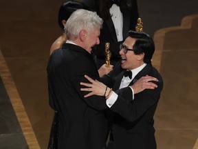 Ke Huy Quan receives the Oscar for Best Picture from Harrison Ford after "Everything Everywhere All at Once" won during the Oscars show at the 95th Academy Awards in Hollywood, Los Angeles, California, U.S., March 12, 2023.