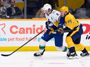 Vancouver Canucks centre J.T. Miller (9) moves the puck in front of Nashville Predators center Matt Duchene (95) during the first period of an NHL hockey game Tuesday, Feb. 21, 2023, in Nashville, Tenn.
