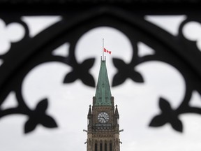 The Canadian flag flies over the Peace Tower in Ottawa at half mast to recognize the National Day of Observance for COVID.
