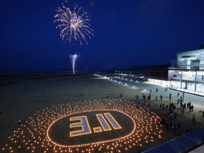 People watch fireworks to mark the 12th anniversary of 2011 earthquake, tsunami and nuclear disaster, in Futaba, Fukushima Prefecture on March 11, 2023.