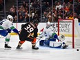 Vancouver Canucks goaltender Collin Delia (60) blocks the shot of Anaheim Ducks centre Sam Carrick (39) as defenceman Ethan Bear (74) helps defend during the first period at Honda Center.
