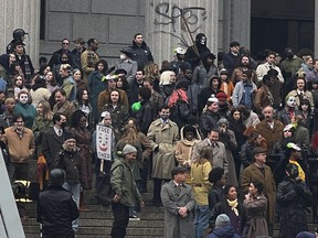 Throngs of actors portraying protesters, some in make-up, gather outside a courthouse for the filming of a scene in the "Joker" movie sequel in New York, Saturday, March 25, 2023. Production crews had to wrestle with the possibility that filming could be disrupted by real-life protests over the Trump case, none of which have materialized so far.