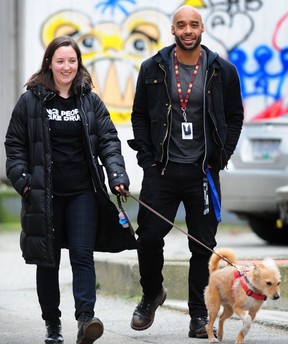 Elaine Durand and Carlos Mendez Espinoza walk with support dog Gael.