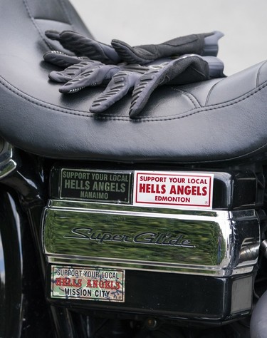 A pair of riding gloves sits on the seat of a motorcycle parked out front of the Nanaimo Hells Angels' clubhouse in Nanaimo, BC, July, 20, 2018.