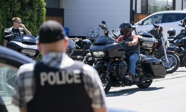 Members of The Combined Forces Special Enforcement Unit of British Columbia keep watch as members of the Hells Angels arrive at the Nanaimo Hell Angels' clubhouse in Nanaimo, BC, July, 21, 2018.