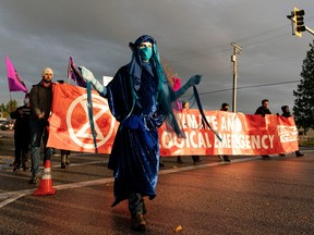 Climate activists belonging to the group Extinction Rebellion stage a protest and block the road leading to the Vancouver International Airport in Richmond, BC, October, 25, 2021.