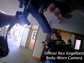 Metropolitan Nashville Police Department Officer Rex Engelbert points his weapon while firing at the mass shooting suspect in The Covenenant School, in a still image from body camera video in Nashville, Tennessee, U.S. March 27, 2023.