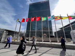People walk past United Nations headquarters in New York on March 3, 2023.