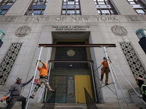 Workers remove scaffolding at the New York Courthouse at 80 Centre Street where Manhattan District Attorney Alvin Bragg continues his investigation into former U.S. President Donald Trump, in Manhattan, New York City, U.S., March 18, 2023.