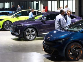 Volkswagen employees stand next to Volkswagen electric cars during a ceremony at German carmaker Volkswagen's first battery cell production plant 'SalzGiga' in Salzgitter, Germany, July 7, 2022.