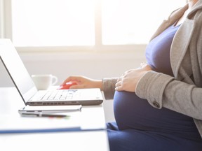pregnant woman is working on computer laptop and mobile phone, business
