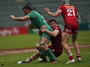 Ireland's Chay Mullins, left, is tackled by Canada's Phil Berna during the 9th place quarterfinal match of the Hong Kong Sevens rugby tournament in Hong Kong, Sunday, April 2, 2023.