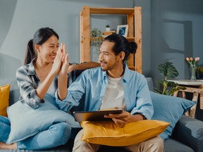 Simplii Financial and CIBC clients can now transfer money overseas with no fees, in real-time, with bank-grade security. Young married moving home shopper online concept.