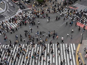 Crowds criss-cross Shibuya Crossing, one of the busiest intersections in the world, in Tokyo.