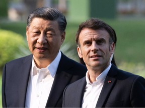 Chinese President Xi Jinping (L) and French President Emmanuel Macron (R) visit the garden of the residence of the Governor of Guangdong, on April 7, 2023, where Chinese President XI Jinping's father, XI Zhongxun lived.