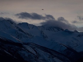 A helicopter flies past a mountain near McBride, B.C., on Saturday January 30, 2016.