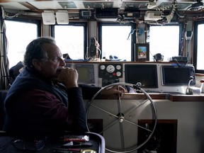 Bob Maharry sits inside his fishing boat docked at Pier 45 in San Francisco, Monday, March 20, 2023. This would usually be a busy time of year for Maharry and his crew as salmon fishing season approaches. On April 7, the Pacific Fishery Management Council, the regulatory group that advises federal officials, will take action on what to do about the 2023 season for both commercial and recreational salmon fishing.