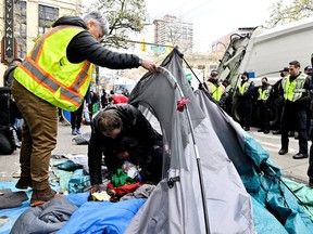 Residents pack up their belongings under the supervision of Vancouver Police.