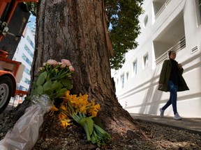 A woman walks past flowers left outside an apartment building where a technology executive was fatally stabbed in San Francisco, Wednesday, April 5, 2023. Bob Lee, a technology executive who created Cash App and was currently chief product officer of MobileCoin, was fatally stabbed in San Francisco early Tuesday, April 4, 2023, according to the cryptocurrency platform and police.
