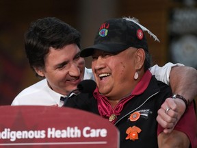 Prime Minister Justin Trudeau embraces Wayne Christian (Wenecwtsin), right, First Nations Health Authority Deputy Chair, as he jokes about knowing the prime minister's late father, former prime minister Pierre Elliott Trudeau, while speaking during an announcement about First Nations health-care funding at the Squamish First Nation, in West Vancouver, B.C., on Friday, April 14, 2023.