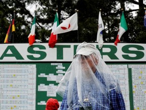 A man is seen wearing a rain cover as play is suspended for the second time due to inclement weather conditions during the second round 
REUTERS/Jonathan Ernst