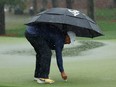 Brooks Koepka of the U.S. marks his ball position on the 7th hole green as play is suspended due to inclement weather conditions during the third round REUTERS/Jonathan Ernst