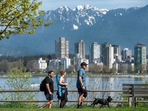 People take advantage of the clear skies and warm weather at Vanier Park in Vancouver.