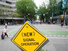 Pedestrians cross the street on an all-walk crosswalk at Robson and Hornby Streets in 2019.