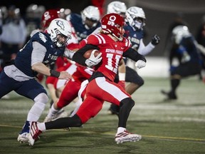 Simon Fraser University Red Leafs Robert Meadors runs the ball downfield while trying to avoid being tackled by Luke Burton-Krahn of the cross-town rivals the UBC Thunderbirds during the 34th Shrum Bowl at SFU Friday, December 2, 2022.