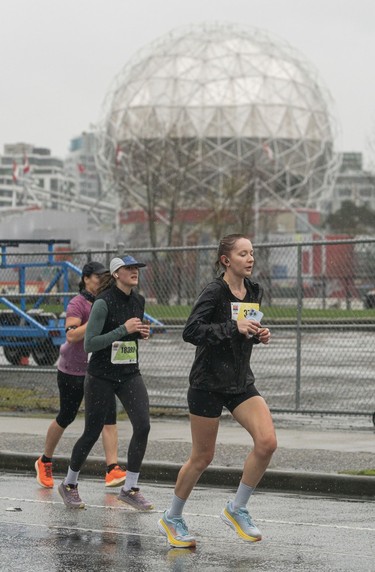 Runners run past Science World along Quebec Street and Pacific Blvd. in the 2023 Sun Run in Vancouver on April 16, 2023.