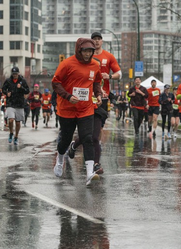 Dongwoo Lee runs through the rain during the 2023 Sun Run in Vancouver on April 16, 2023.