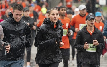 Rain soaked runners make their way along the course of the 2023 Sun Run in Vancouver on April 16, 2023.