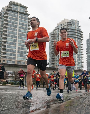 William Gumboc (left) and Kobe Kubota run along Pacific Blvd during the 2023 Sun Run in Vancouver on April 16, 2023.