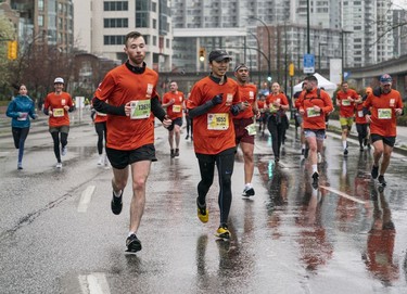 Runners run in the rain along Quebec Street Pacific Blvd during the 2023 Sun Run in Vancouver on April 16, 2023.