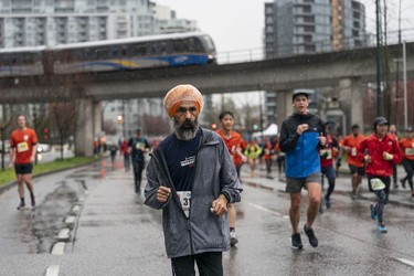 Runners try and stay dry for the 2023 Sun Run in Vancouver on April 16, 2023.