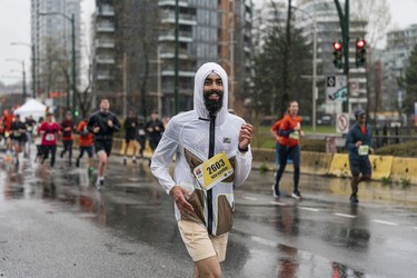 Runners try and stay dry for the 2023 Sun Run in Vancouver on April 16, 2023.