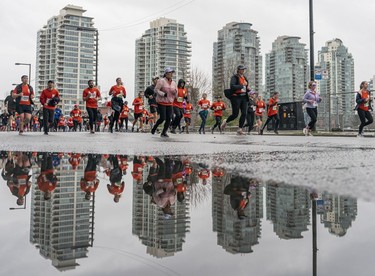 Runners run along Pacific Blvd. during the 2023 Sun Run in Vancouver on April 16, 2023.