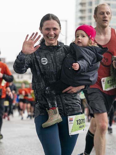Aelita MacIver takes her her daughter the cross the finish line of the 2023 Sun Run in Vancouver on April 16, 2023.