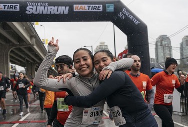 Jechie Tongco (left) and Cherry Reyes embrace upon completing the 2023 Sun Run in Vancouver on April 16, 2023.