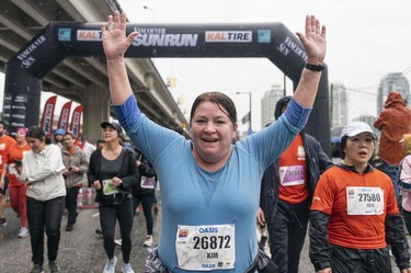 Vancouver Sun reporter Kim Bolan crosses the finish line to complete the 2023 Sun Run in Vancouver on April 16, 2023.
