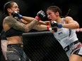 Julianna Pena, right, hits Amanda Nunes during a women's bantamweight mixed martial arts title bout at UFC 269 on Dec. 11, 2021, in Las Vegas.