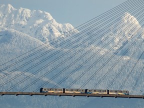 A Skytrain crosses over the Fraser River past snow-capped mountains in the distance, in New Westminster, B.C., Tuesday, Dec. 28, 2021. British Columbia should prepare for a long, cool spring that is expected to persist over much of the province.