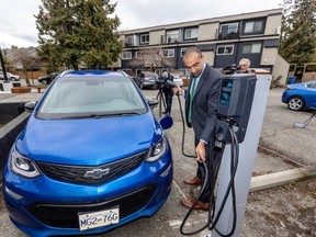 Housing Minister Ravi Kahlon charges an electric car at 50 Montreal St. in James Bay during the announcement Thursday. DARREN STONE, TIMES COLONIST