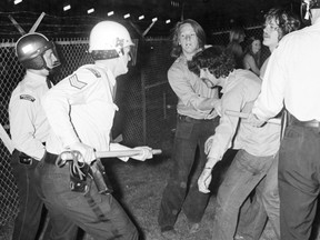 Police wielding clubs face off with rioters outside a 1972 Rolling Stones concert.