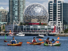 Kayakers enjoy the sunny weather in False Creek in Vancouver.