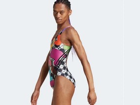 A women's one-piece Pride swimsuit is modelled by a male on the Adidas website.