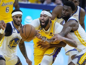 Los Angeles Lakers forward Anthony Davis, middle, reaches for the ball between Golden State Warriors guard Gary Payton II (8) and forward Andrew Wiggins during the first half of Game 5 of an NBA basketball second-round playoff series Wednesday, May 10, 2023, in San Francisco.