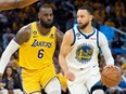 Golden State Warriors guard Stephen Curry dribbles the ball against Los Angeles Lakers forward LeBron James during Game 5 of the 2023 NBA playoffs conference semifinals at the Chase Center in San Francisco.