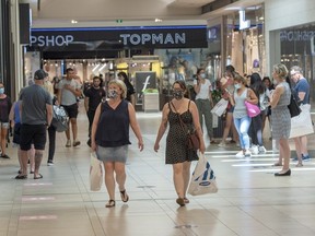 Shoppers walk through Carrefour Laval shopping centre as malls across Quebec reopened amid the COVID-19 pandemic, Friday, June 19, 2020 in Laval, Que.